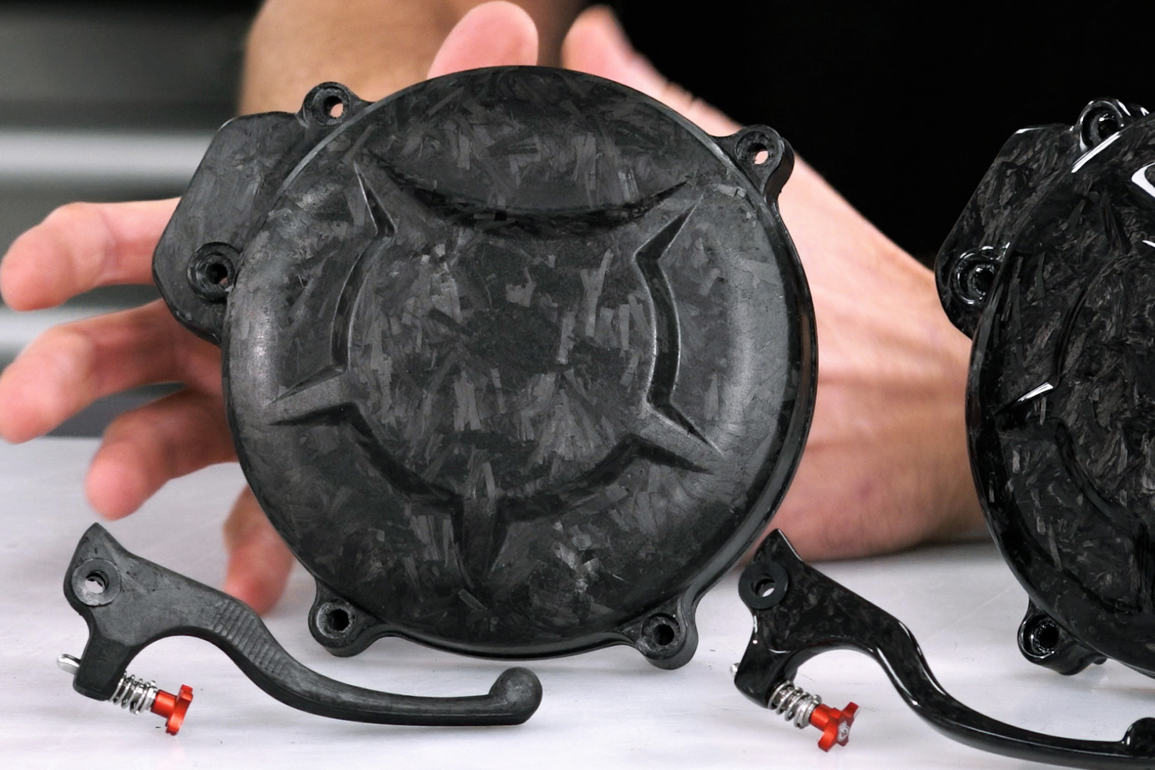 A clutch cover and a brake lever made of forged carbon fiber