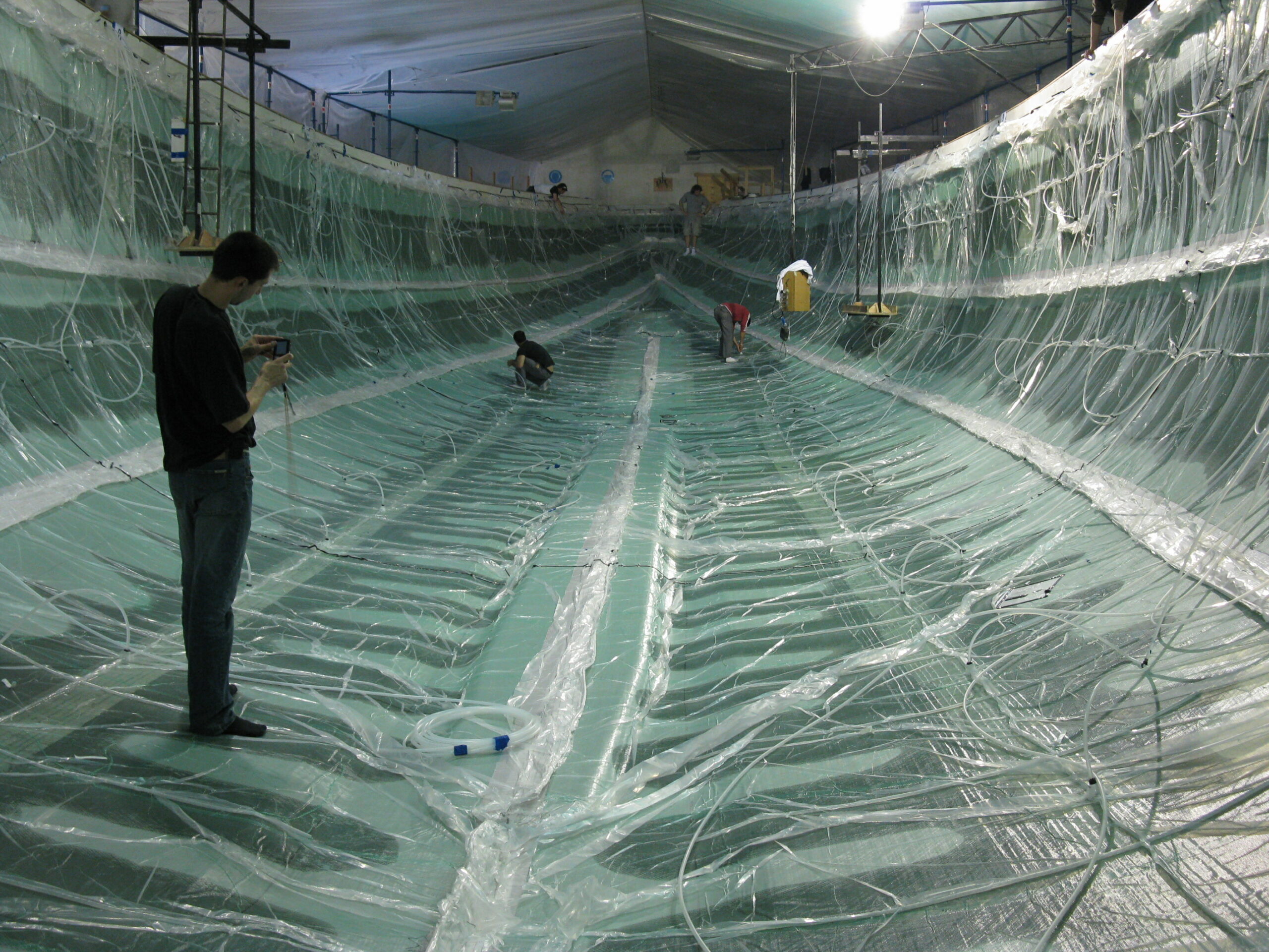 Large-scale composite vacuum infusion setup inside a mold with vacuum bagging and resin lines